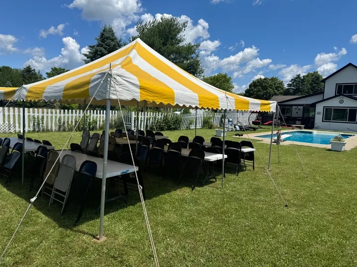 Blue and white striped party tent rental with tables and chairs in Mid-Michigan